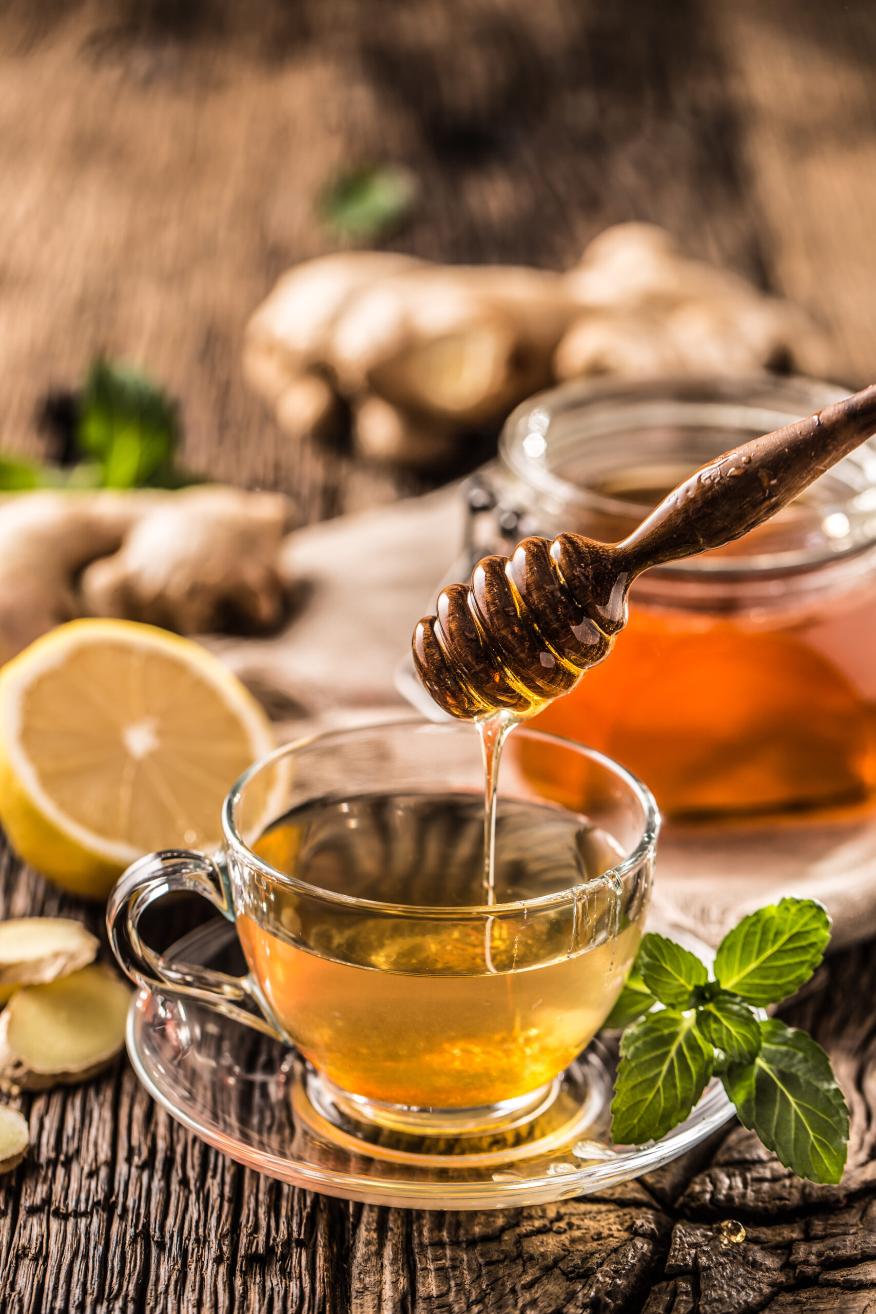 Ginger tea honey lemon and mint leaves on wooden table.